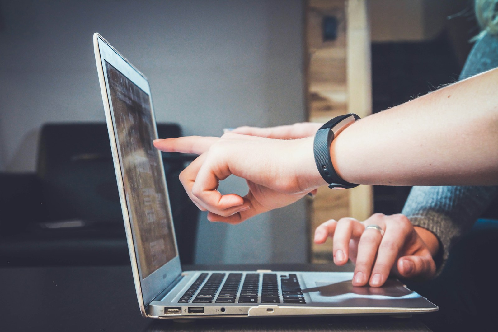 Two people collaborating beside a laptop in a bright workspace